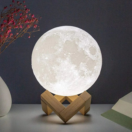 An LED battery moon lamp with a realistic lunar texture, placed on a wooden stand, emitting a soft white glow.