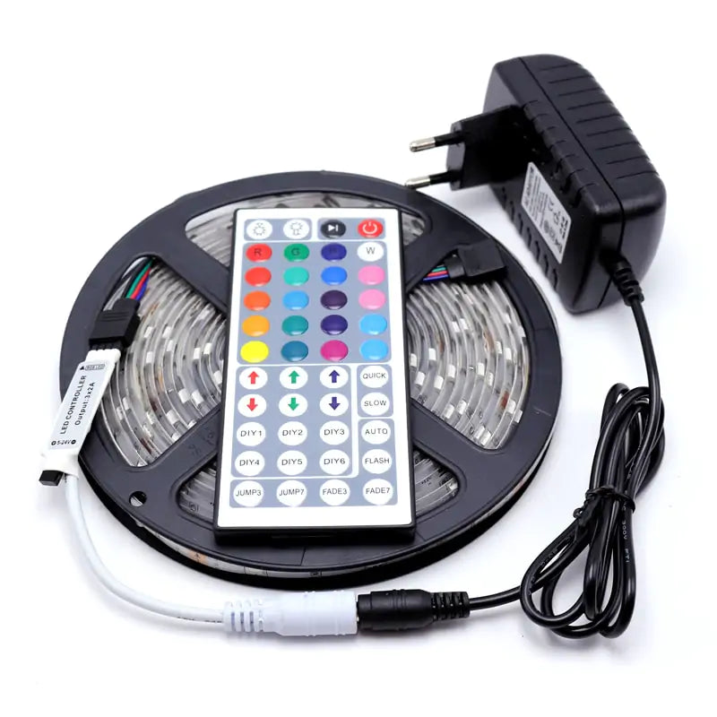 A reel of flexible LED strip light with a remote control and power supply.